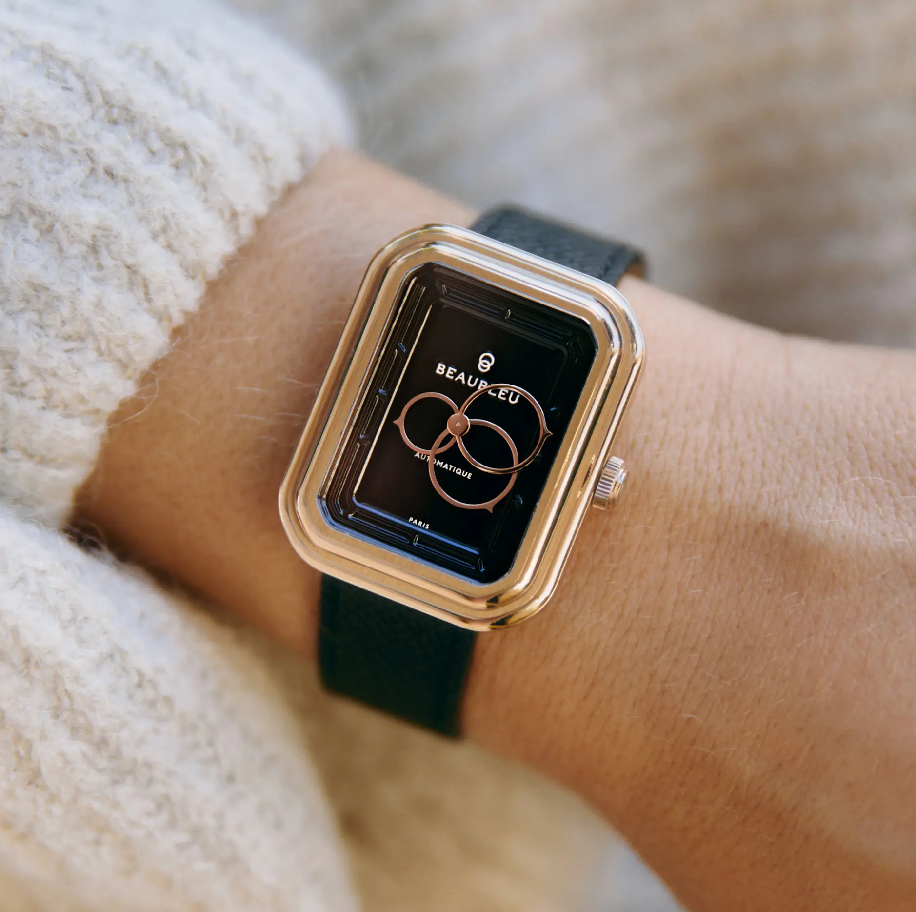 Montre automatique Beaubleu Figura Onyx portée sur un poignet de femme avec un pull en laine blanc