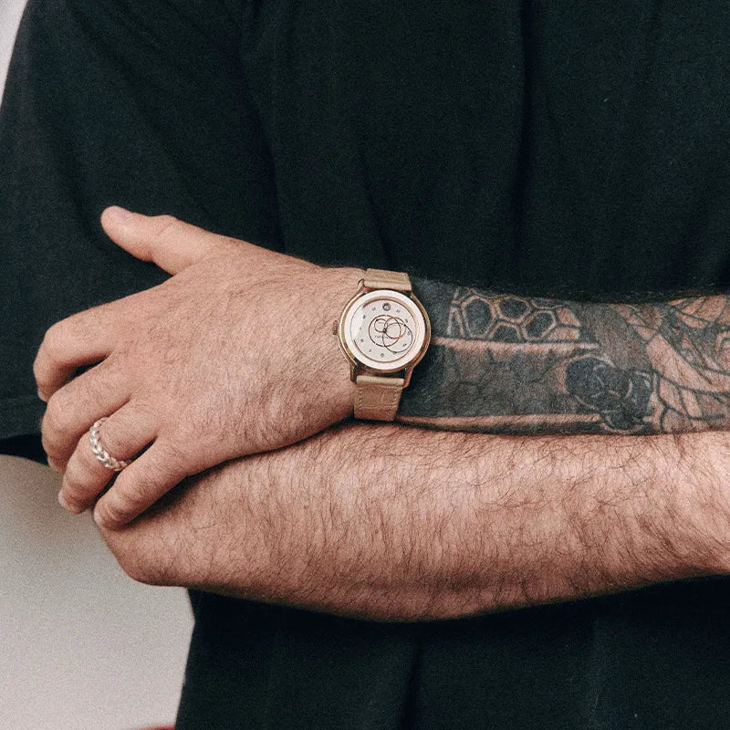 Montre Beaubleu portée avec le bracelet Flat White crème sur un poignet tatoué
