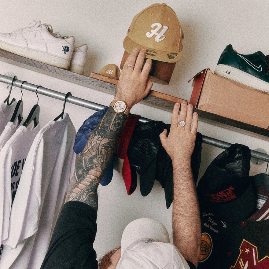Montre Beaubleu Ecce Lys avec bracelet Flat White portée lors du choix d’une casquette sur une étagère
