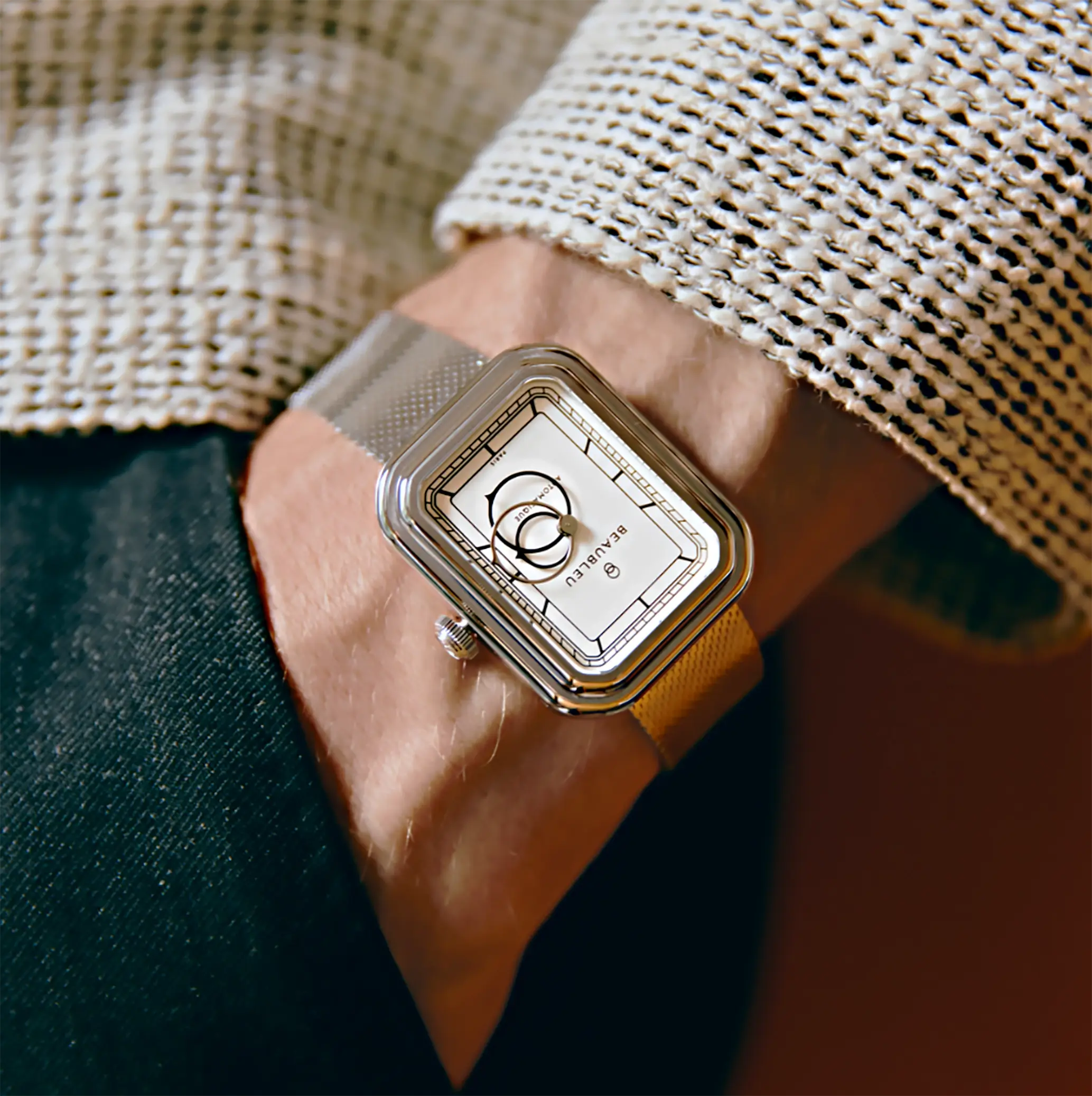 Zoom sur la Ecce Figura Alba portée par un homme en costume avec la main dans la poche