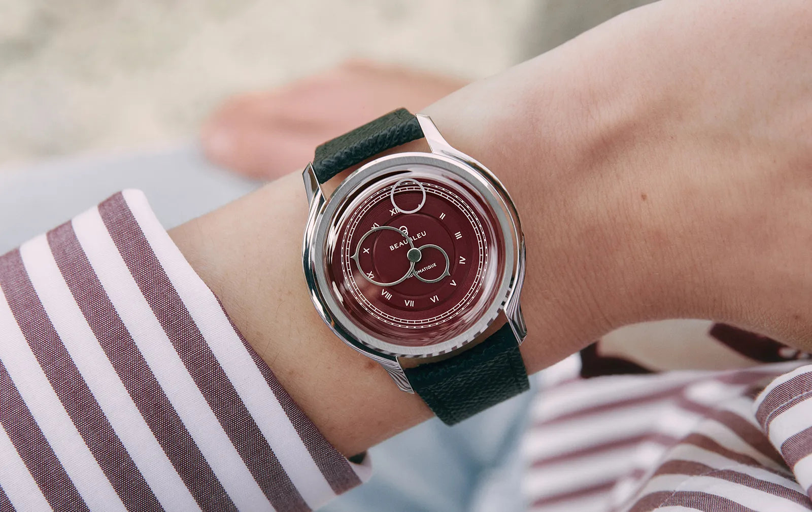 Montre Beaubleu au cadran bordeaux portée au poignet avec bracelet en cuir noir grainé