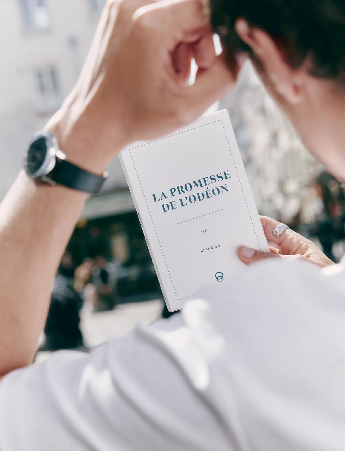 Personne lisant un livre tout en portant une montre Beaubleu au poignet