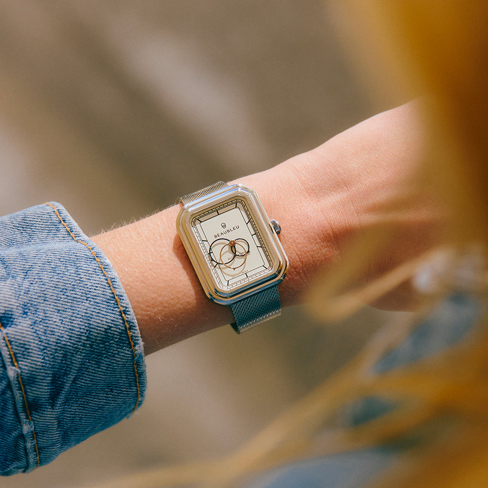 Montre Ecce Figura Alba au cadran blanc portée par une personne en veste en jean, dans un environnement extérieur