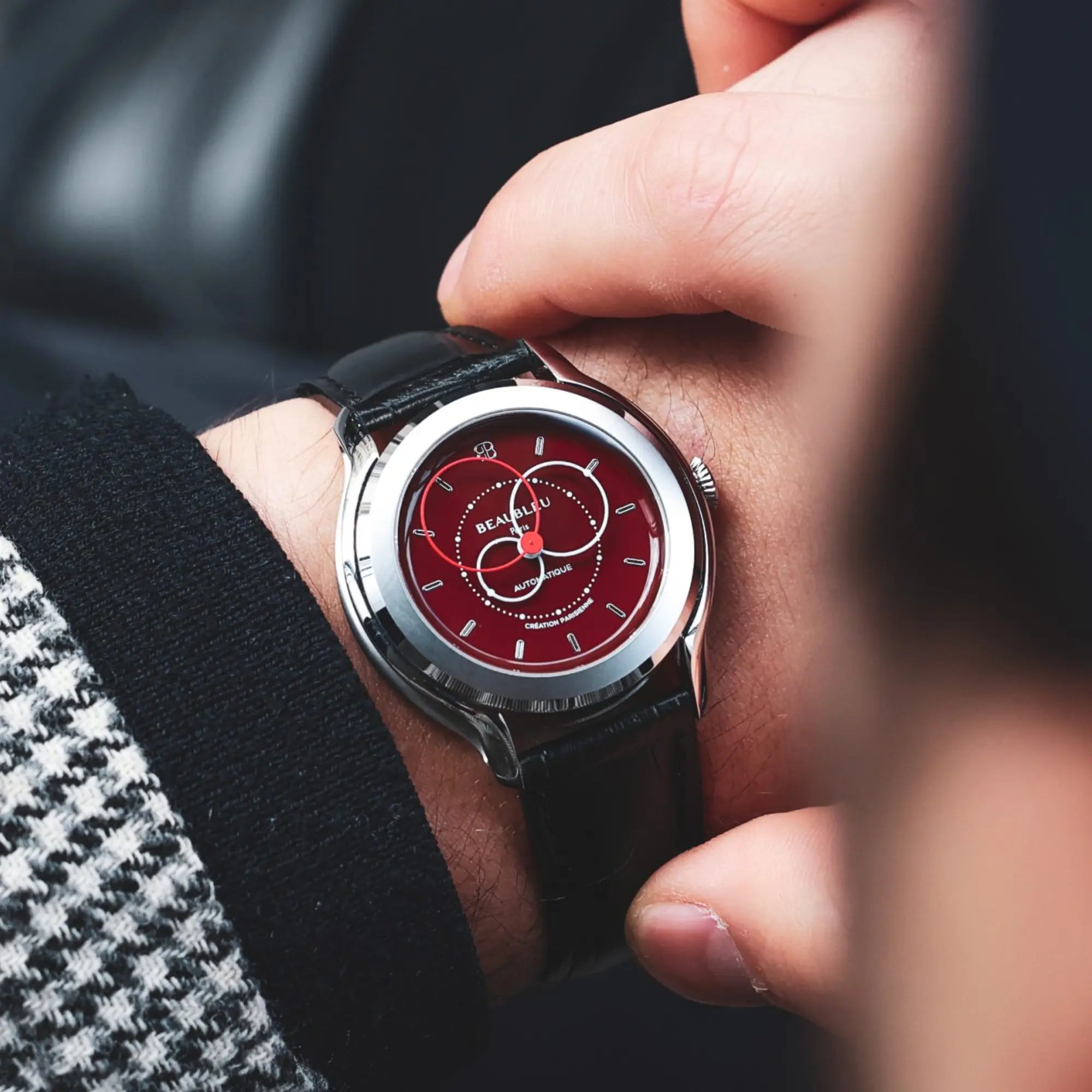 Montre Brio Rouge au poignet d'un homme veste pied de poule
