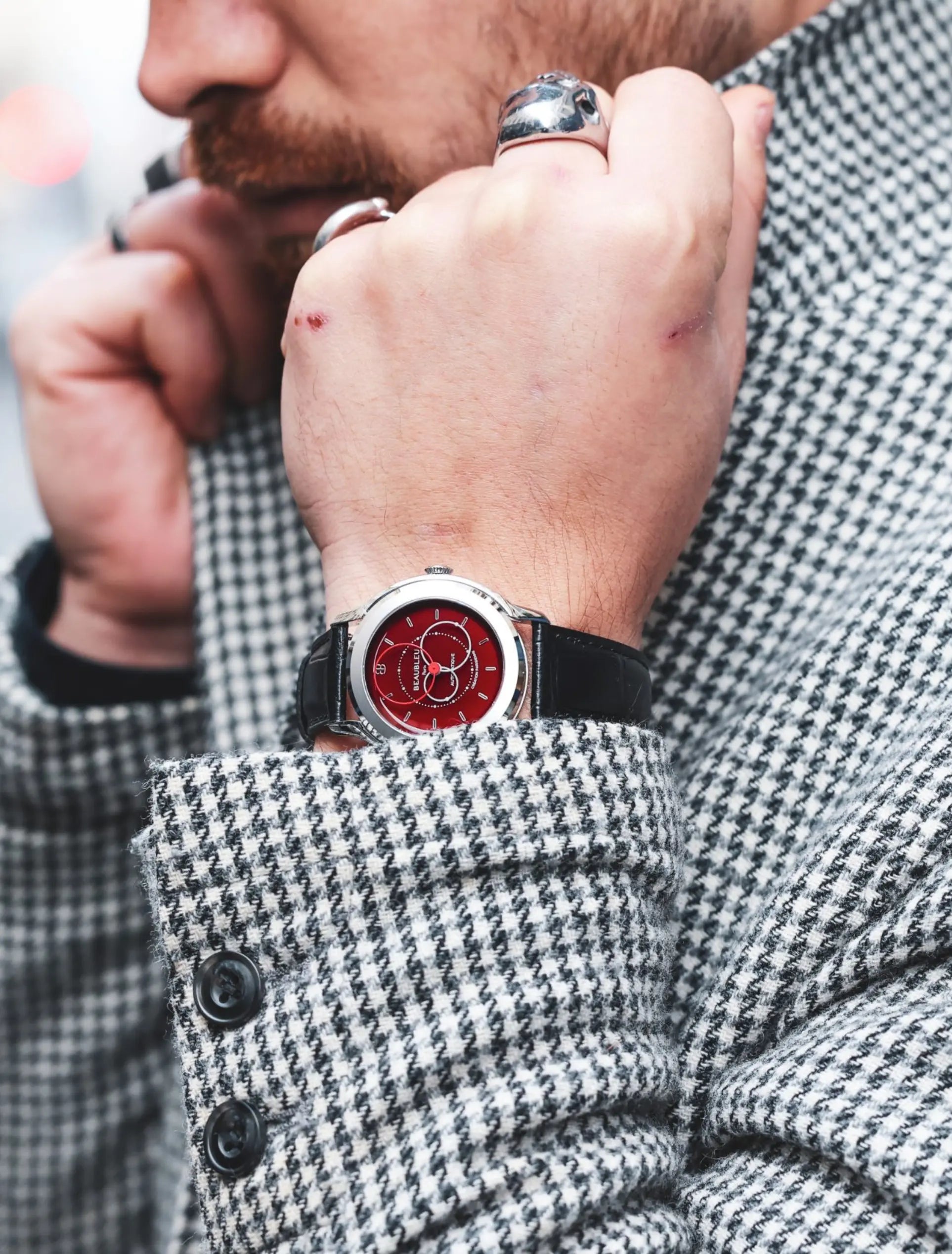 Montre Brio Rouge au poignet d'un homme veste pied de poule