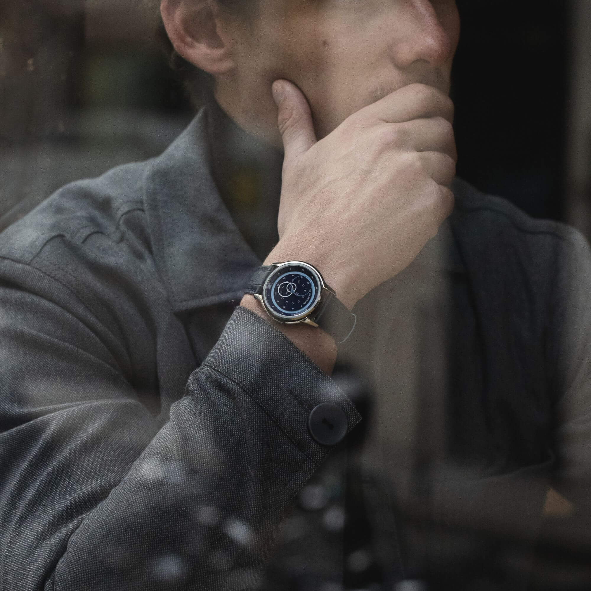 Montre GMT Bleu avec un bracelet en cuir noir portée au poignet d'un homme