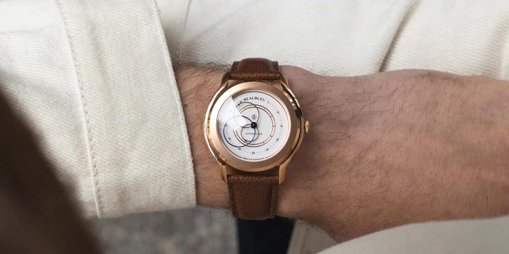 Montre Union Olympe sur bracelet cuir grainé cognac au poignet d'un homme