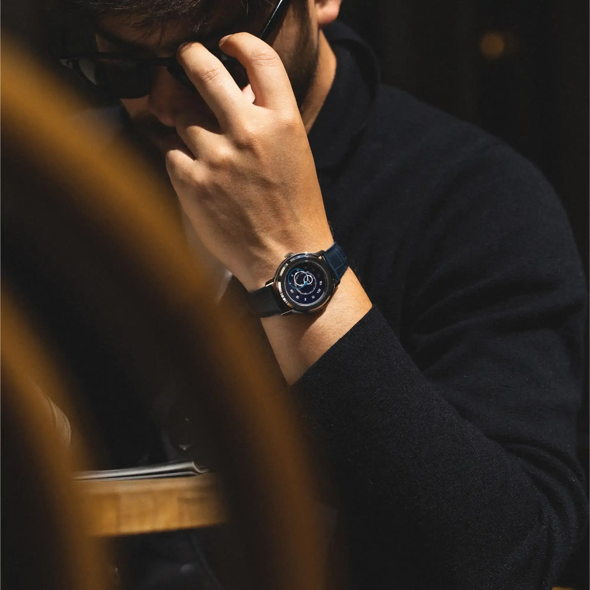 Montre Origine bleu sur bracelet cuir bleu au poignet d'un homme