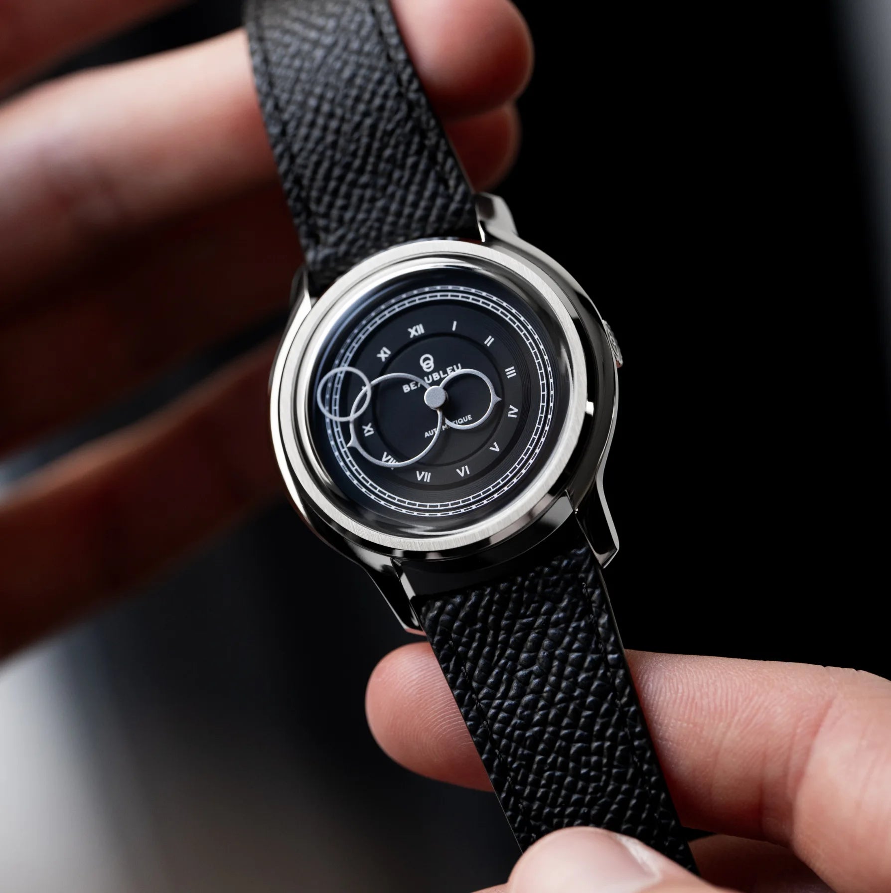Montre La Pièce Graphite de Beaubleu avec bracelet en cuir grainé tenue dans les mains