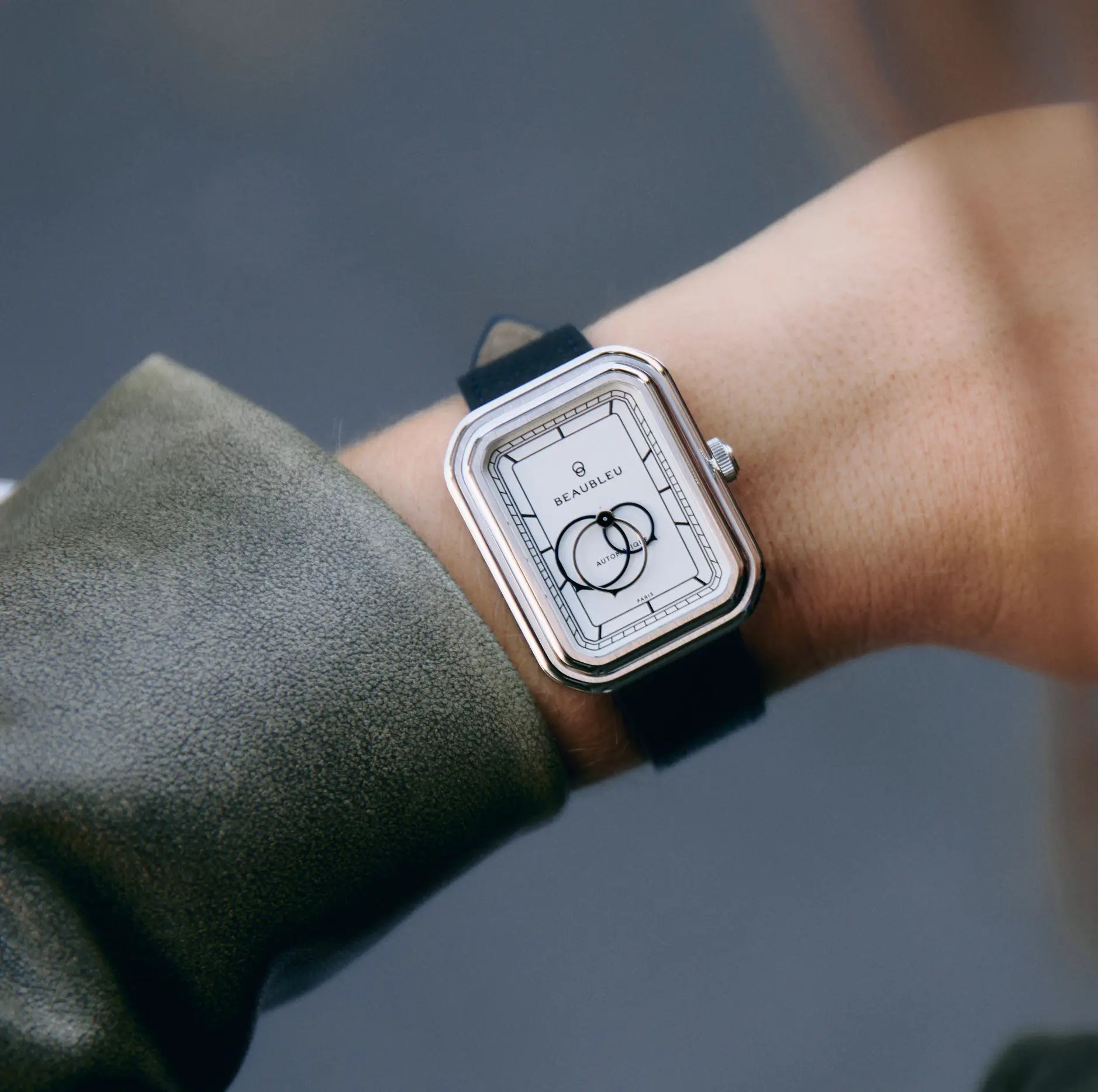 Ecce Figura Alba portée au poignet d'une femme avec une veste en cuir