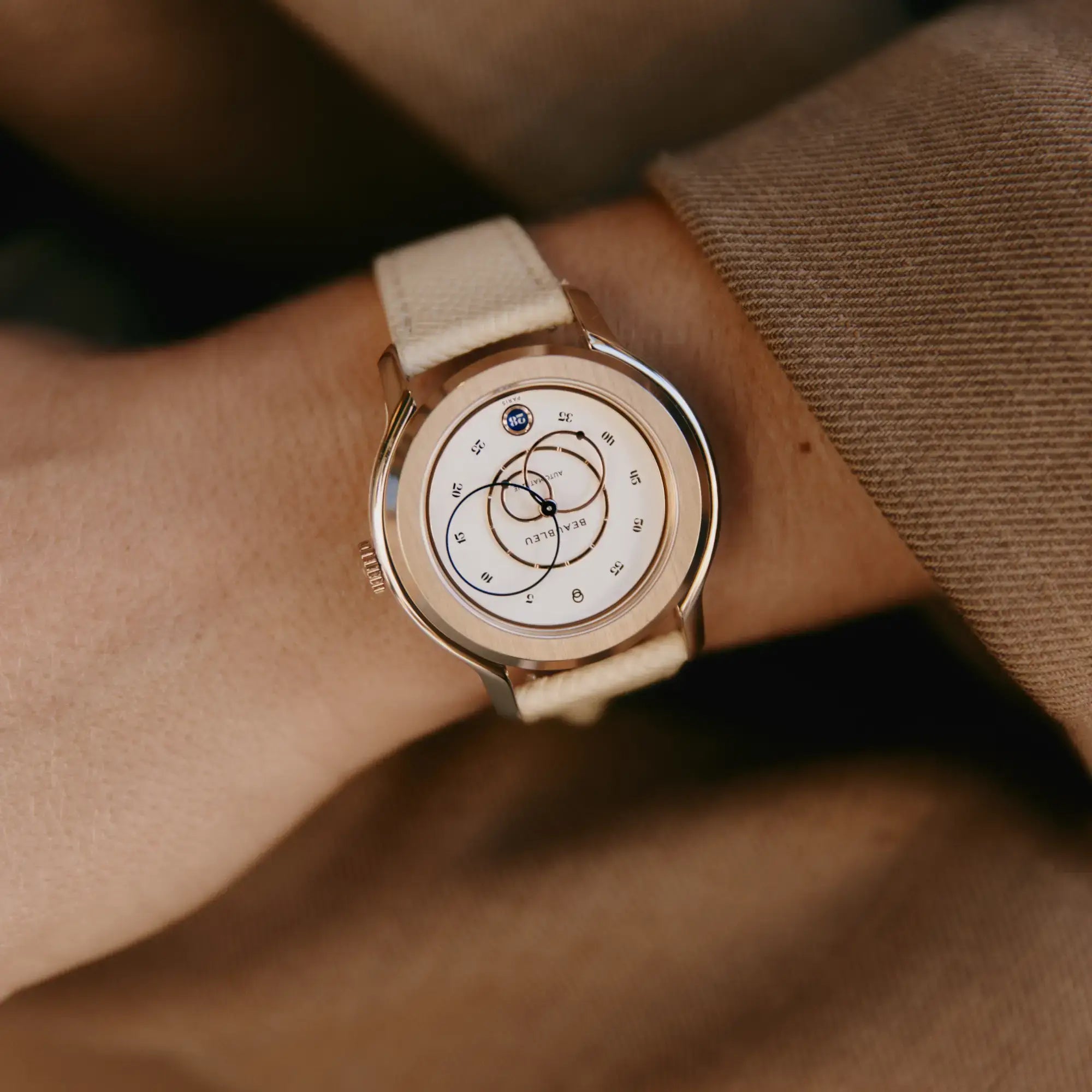 montre automatique beaubleu ecce lys au poignet d'une femme qui porte une veste