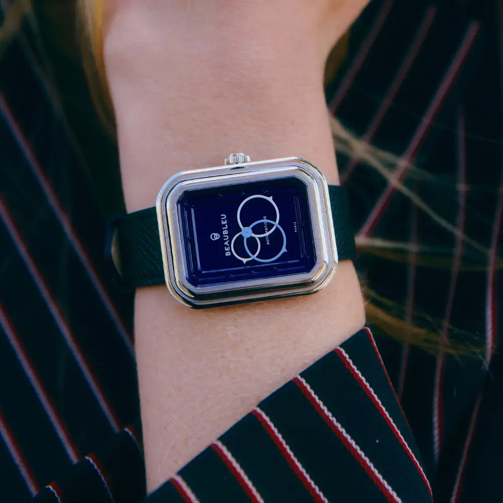 Montre automatique Ecce Figura Smalt portée sur un poignet féminin, vêtue d’un haut rayé bleu marine et rouge