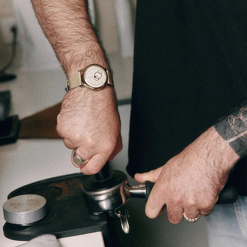 Montre Beaubleu La Pièce Champagne équipée du bracelet Flat White portée lors de la préparation d’un espresso