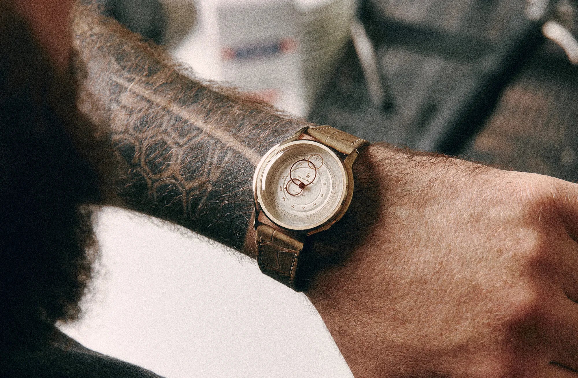 Montre Beaubleu avec bracelet Flat White portée au poignet d'un homme tatoué