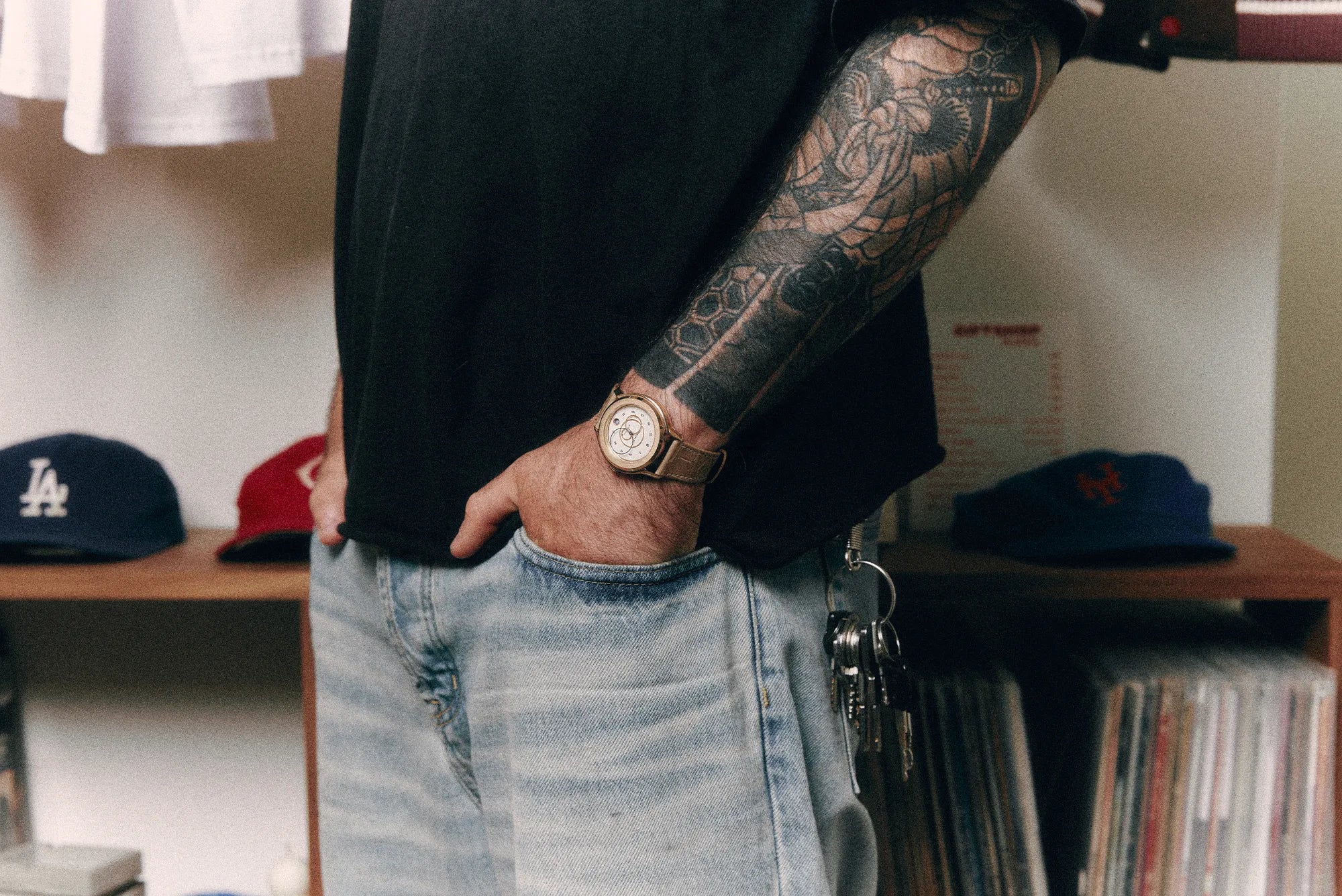 Montre Beaubleu et bracelet Flat White portés avec un look casual devant une collection de vinyles