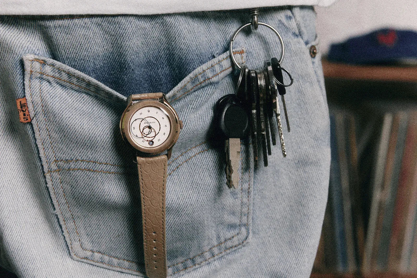 Montre Beaubleu Ecce Lys équipée d'un bracelet Flat White en alligator suspendue à une poche de jean.