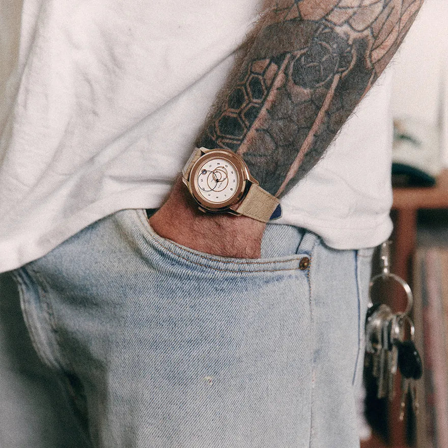 Gros plan sur une montre Beaubleu Ecce Lys avec bracelet Flat White portée avec un jean clair