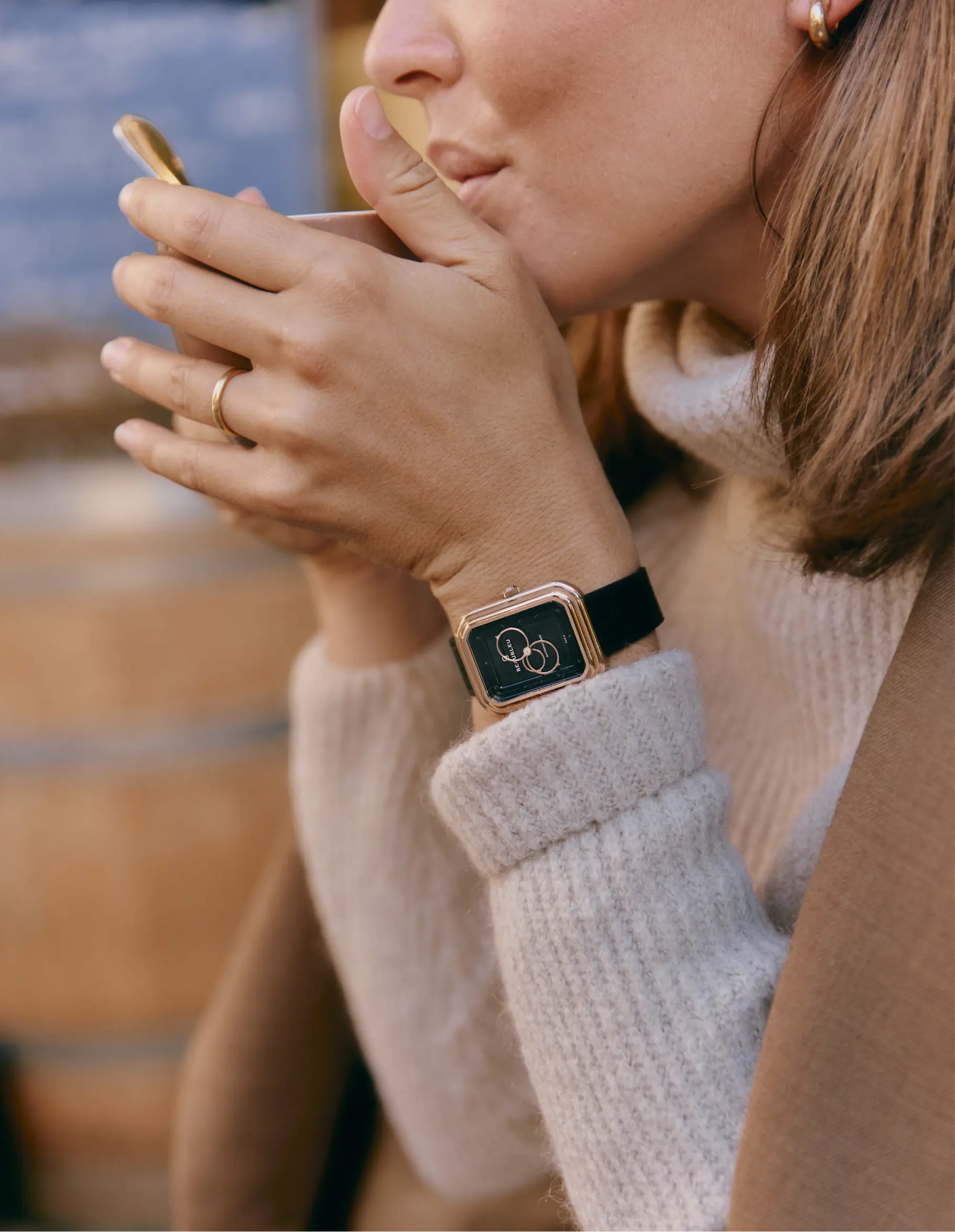 Montre automatique Beaubleu Ecce Figura Onyx portée au poignet d'une femme buvant un café