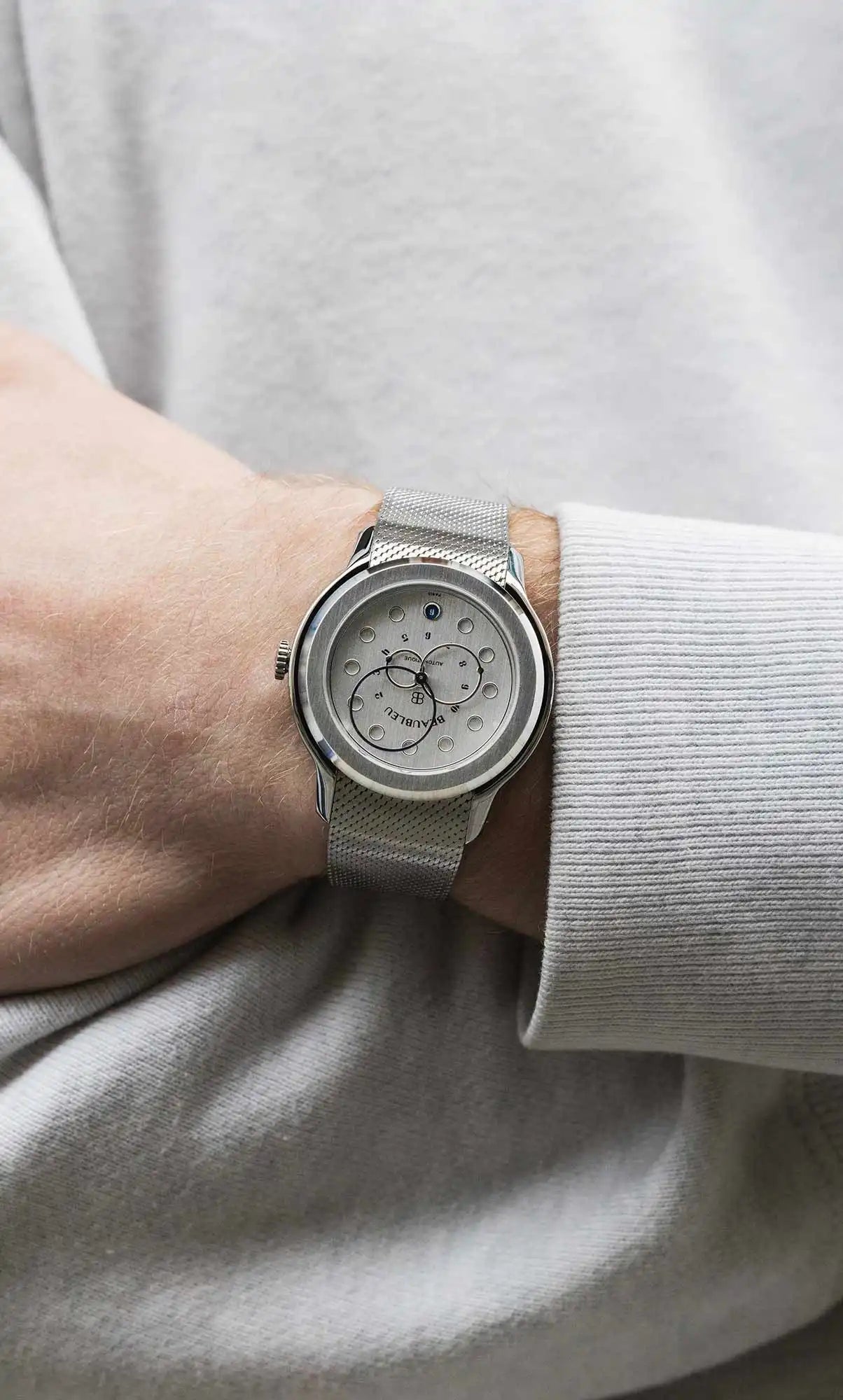 MOntre date acier au poignet pull gris