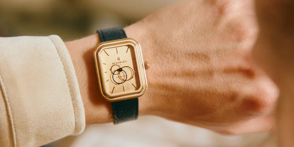 Montre Beaubleu Figura Sienna portée au poignet, avec un arrière-plan flouté aux tons chauds
