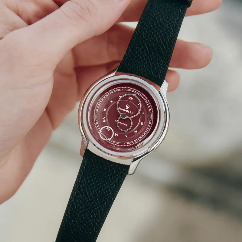 Montre La Pièce Lie de Vin de Beaubleu avec bracelet grainé tenue dans les mains