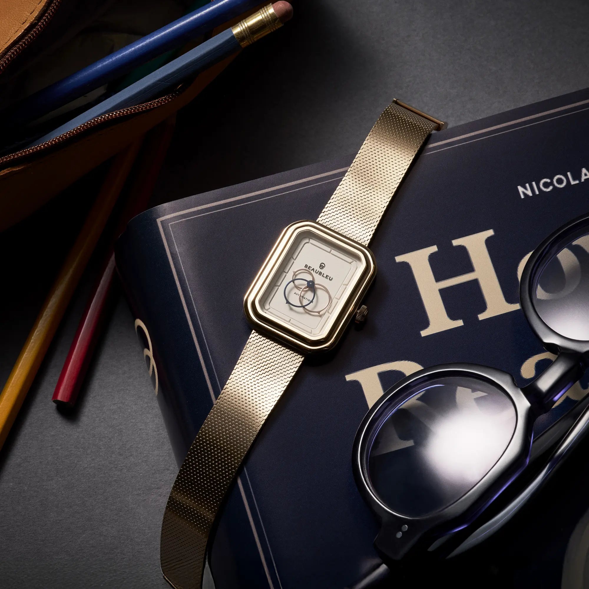 Montre Ecce Figura Lys avec son bracelet en maille tressée, posée sur un livre