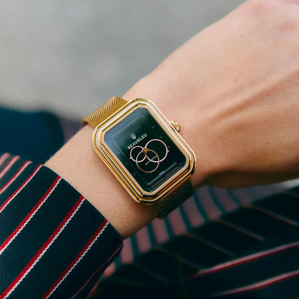 Montre automatique au boitier octogonal avec un cadran noir et un bracelet en acier or rose