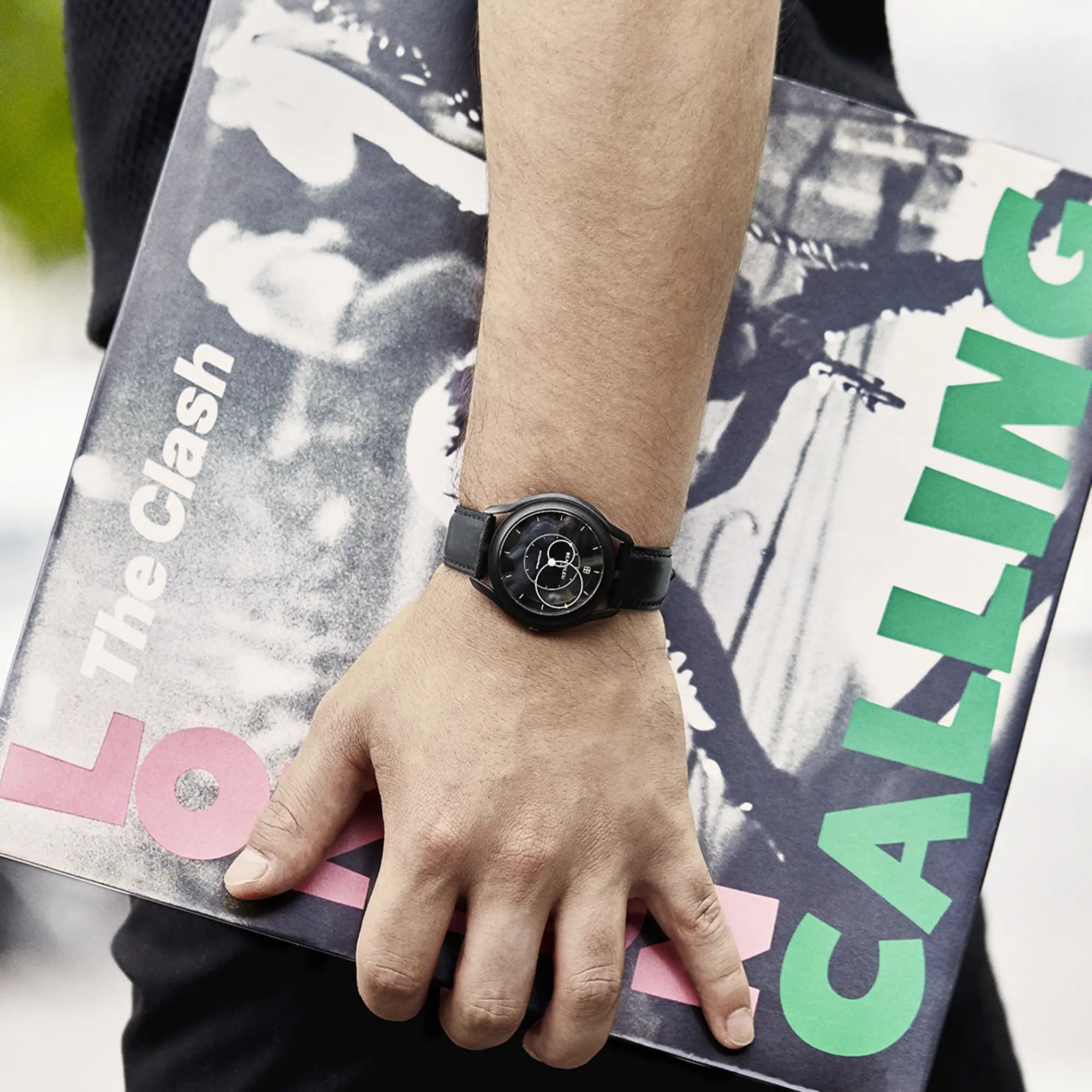 Homme avec une pochette de vinyle et Beaubleu Le mysterieux au poignet