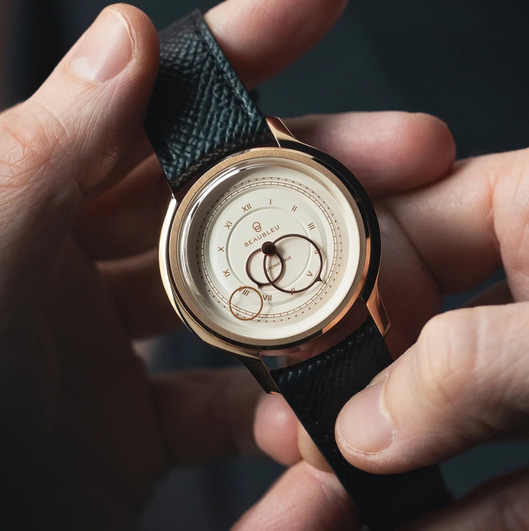 Montre La Pièce Champagne de Beaubleu avec bracelet cuir grainé tenue dans les mains