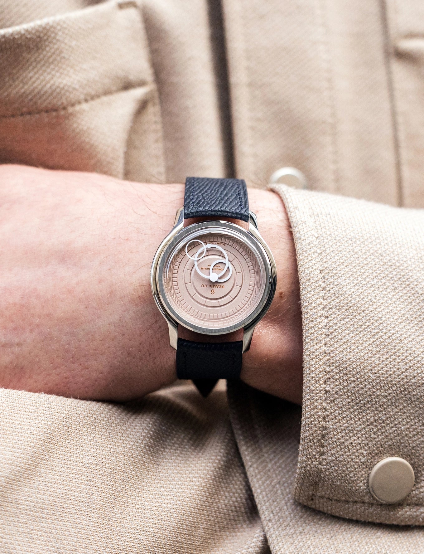 Montre Seconde Française saumon portée par homme avec bras croisés